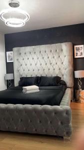 a bedroom with a large bed with a large headboard at Suite jacuzzi "spa privatif " appartement Jacuzzi in Toulouse