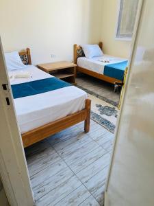 bianco Hotel & Suites في مرسى مطروح: سريرين في غرفة مع باب مفتوح