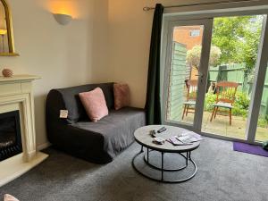 a living room with a couch and a table at Comfortable Home away from Home, spacious 2 bedroom town house,self catering, free parking, walking distance to Cheltenham town centre in Cheltenham