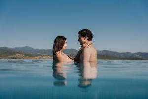 a man and a woman sitting in the water at Bajo Estrellas Hotel Contemporáneo in Valle de Guadalupe