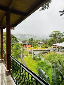 a balcony with a view of a river and a bridge at La Casa de Cecilia Mindo in Mindo