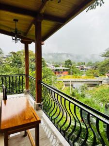 a balcony with a bench and a view of a river at La Casa de Cecilia Mindo in Mindo