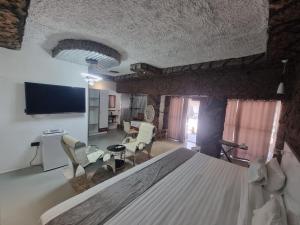 ein Wohnzimmer mit einem Tisch und Stühlen sowie einem TV in der Unterkunft Rustiek Hotel in Kasane