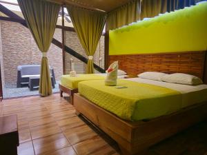 ein Schlafzimmer mit 2 Betten in einem Zimmer mit gelber Wand in der Unterkunft Caribbean Sea Towers Hotel in Puerto Viejo
