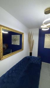 a living room with a blue couch and a mirror at Suite jacuzzi "spa privatif " appartement Jacuzzi in Toulouse