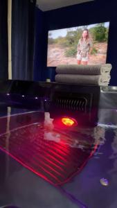 - un jeu vidéo avec une lumière rouge devant une télévision dans l'établissement Suite jacuzzi "spa privatif " appartement Jacuzzi, à Toulouse