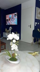 una habitación con una mesa con flores blancas. en Suite jacuzzi "spa privatif ", en Toulouse