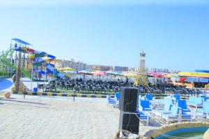The View Aqua Park في مرسى مطروح: شاطئ فيه كراسي ومظلات وحديقة مائية