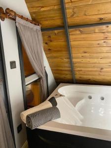 eine Badewanne in einem Zimmer mit einer Holzwand in der Unterkunft bitek bungalov in Trabzon