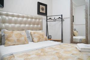 1 dormitorio con 1 cama grande y espejo grande en Dina Beach House Quinzico, en Nazaré