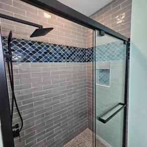 y baño con ducha de cristal y azulejos azules. en Entire Upper Floor!, en Rockport 57 fotos más