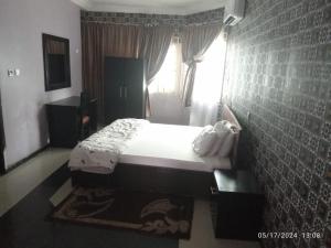 a bedroom with a white bed and a window at The Residence in Uyo