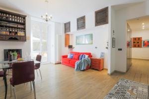 a living room with a red couch and a table at 5 minuti dal mare Favoloso Trilocale con giardino in Genova
