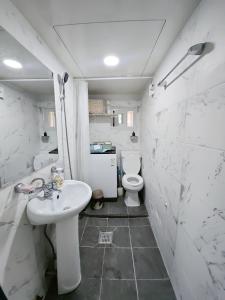 a white bathroom with a sink and a toilet at You Here,Stay - 5min to Hapjeong Station, 10mins to Hongdae in Seoul
