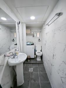 une salle de bain blanche avec un lavabo et des toilettes dans l'établissement You Here,Stay - 5min to Hapjeong Station, 10mins to Hongdae, à Séoul