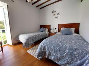 1 dormitorio con 2 camas y ventana en La Braña (Vivienda vacacional en entorno privilegiado), en Bustio