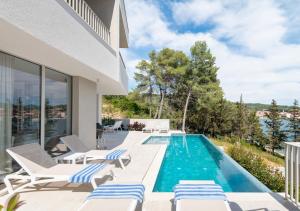 een villa met een zwembad en een patio bij Luxury & stylish Villa Maslina 10 m from the sea in Vela Luka