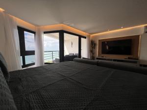 - une chambre avec un grand lit et une grande fenêtre dans l'établissement Particular Deluxe Iate Plaza, à Fortaleza