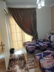 1 dormitorio con 2 camas y ventana en Palmera Beach, en Ain Sokhna