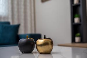 two apples and a gold apple on a table at JnS Premium Stay in Faliraki