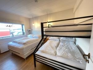 two bunk beds in a room with a window at House in Akranes - Birta Rentals in Akranes