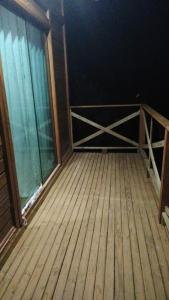 ein leeres Zimmer mit einer Holztür und einem Balkon in der Unterkunft Chalé Sonho Diniz 2 in Monte Verde