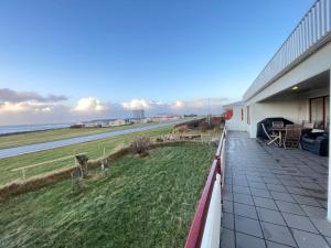 a balcony of a house with a view of the ocean at House in Akranes - Birta Rentals in Akranes