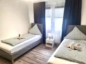 a bedroom with two beds and a window at Free Parking - 2 Schlafzimmer Apart mit 3 Betten in Pforzheim