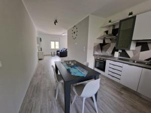 a kitchen with a black table and white chairs at L'AURORA Locazione Turistica in Sulmona