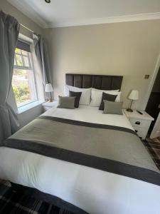 1 cama blanca grande en un dormitorio con ventana en The Ryebeck Hotel, en Bowness-on-Windermere