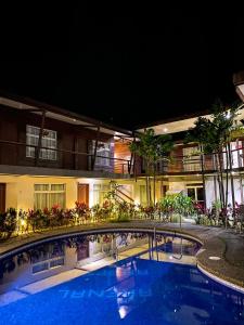 uma piscina em frente a um hotel à noite em Hotel Arenal Rabfer em La Fortuna