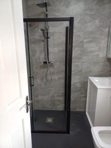 a shower with a glass door in a bathroom at Budgeted Residence near Coventry Building Society (CBS) Arena with Parking in Exhall