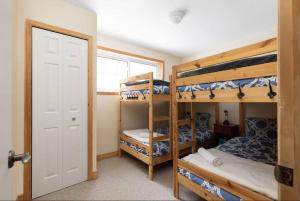a room with three bunk beds and a door at 3BR Rebecca Lakehouse with Fireplace Wifi and Dock in Oxtongue Lake