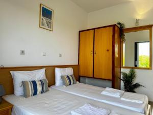 a bedroom with two beds and a cabinet at Elgreco Apartment, at Tigaki, near the sea "4" in Tigaki