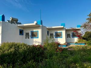 una casa bianca con finestre blu e piante di Elgreco Apartment, at Tigaki, near the sea "2" a Città di Kos