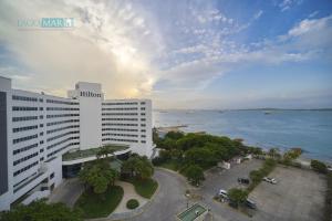 un gran edificio blanco junto a una masa de agua en HomeBeach Conquistador en Cartagena de Indias