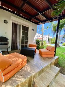 eine Terrasse mit orangefarbenen Möbeln und einem Klavier in der Unterkunft Madonna Pool Beach los Corales in Punta Cana