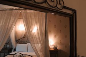 a bedroom with a canopy bed with a mirror at Enastron Hotel in Kato Loutraki