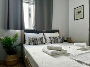 a large white bed with towels on top of it at Modern Apartment in Kos Town, Walking Distance to the Beach - No 4 in Kos Town