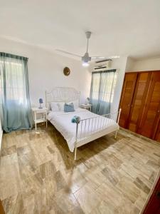 1 Schlafzimmer mit einem weißen Bett und 2 Fenstern in der Unterkunft Madonna Pool Beach los Corales in Punta Cana