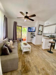 ein Wohnzimmer mit einem Sofa und einem Deckenventilator in der Unterkunft Madonna Pool Beach los Corales in Punta Cana