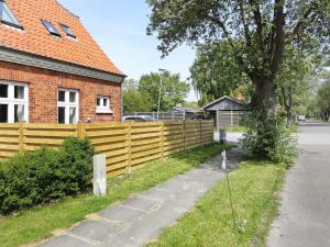 a wooden fence in front of a house at 6 person holiday home in R dby in Rødby