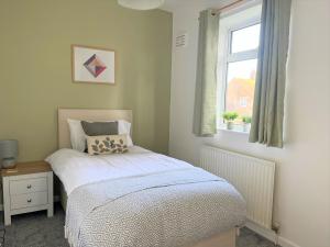 a small bedroom with a bed and a window at Ancaster House - Driveway - Great Contractor Base in Lincolnshire