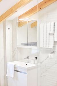 a white bathroom with a sink and a mirror at Nana's Guesthouse in Samos +72 photos
