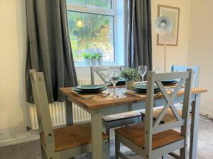 a dining room table and chairs with a table and a window at Ancaster House - Driveway - Wifi in Lincolnshire