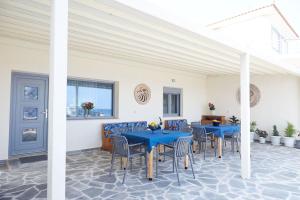 a dining room with blue tables and chairs at Nana's Guesthouse in Samos