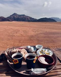 a tray of food with coffee and eggs on a table in the desert at The Rock Camp in Wadi Rum