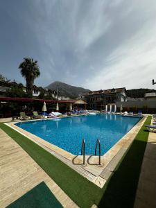 una gran piscina en un complejo con sillas en Carmina Hotel, en Ovacık