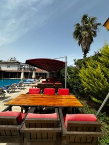 una mesa y sillas de madera y una piscina en Carmina Hotel, en Ovacık