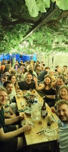 a group of people sitting at a long table at Clover Hostel in Mendoza